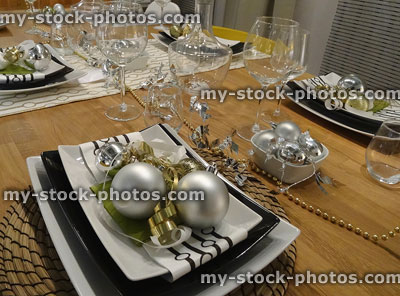 Stock image of Christmas dinner table place settings, napkins, baubles, decorations