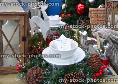 Stock image of festive Christmas dining table with wreath placemats, lantern