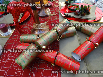 Stock image of Christmas dinner table setting, decorative table cloth runner, crockery / plates, crackers, red deer