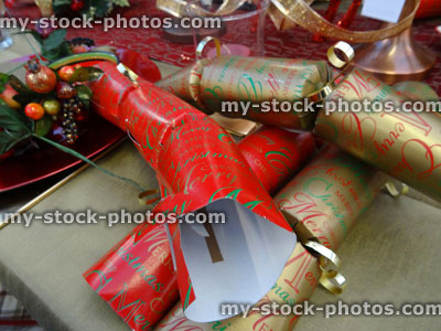 Stock image of Christmas dinner table setting, decorative table cloth runner, crockery / plates, red / gold crackers