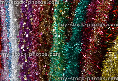 Stock image of tinsel Christmas decorations, red, pink, green, purple, silver, white, gold