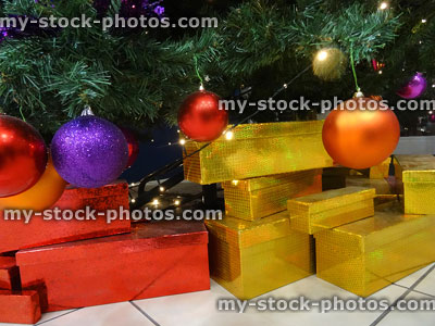 Stock image of wrapped presents beneath Christmas tree with baubles / decorations
