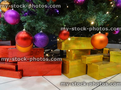 Stock image of gift wrapped presents / parcels waiting under decorated Christmas tree