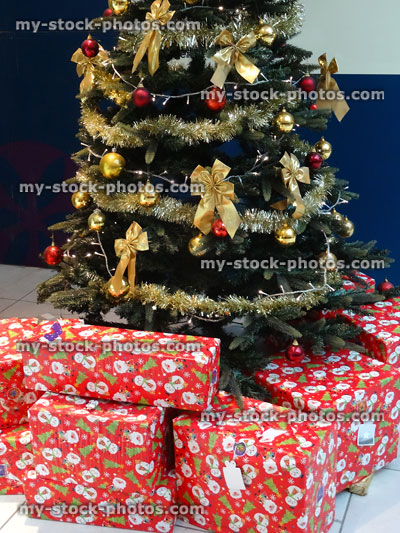 Stock image of Christmas tree with decorations and pile of presents