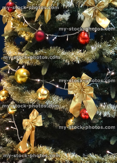 Stock image of Christmas tree with gold baubles, tinsel, bows, decorations
