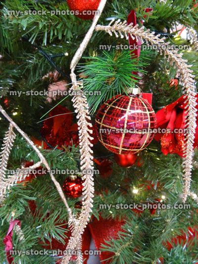 Stock image of artificial Christmas tree decorations, baubles, silver glitter foliage, fairy lights