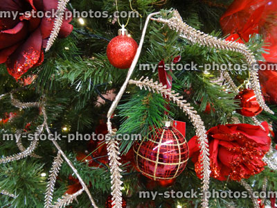 Stock image of artificial Christmas tree decorations, baubles, silver glitter foliage, fairy lights, red roses