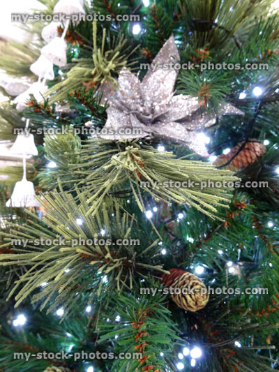Stock image of artificial Christmas tree decorations, baubles, silver stars / bells, fairy lights, poinsettias
