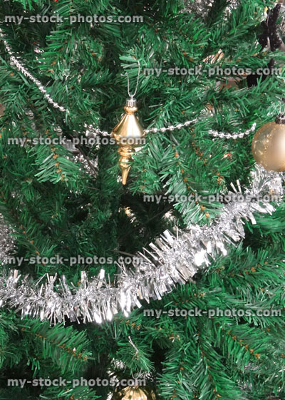 Stock image of artificial Christmas tree, gold / silver decorations, baubles / tinsel, chain beads, garlands