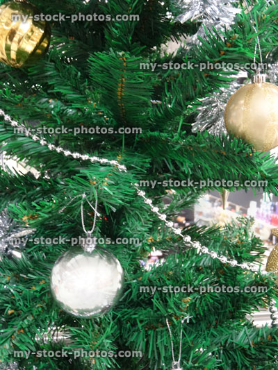 Stock image of artificial Christmas tree, gold / silver decorations, baubles / tinsel, chain beads, garlands