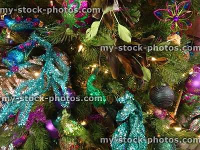 Stock image of artificial Christmas tree, green / turquoise peacock decorations, glitter, flowers, baubles