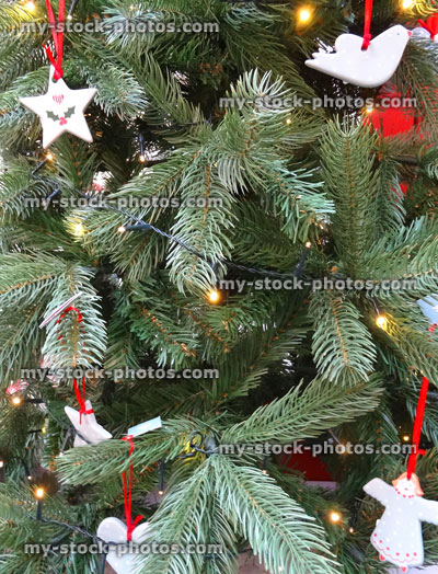 Stock image of artificial Christmas tree decorations, baubles, hanging ornaments, doves, stars, angels, hearts, fairy lights