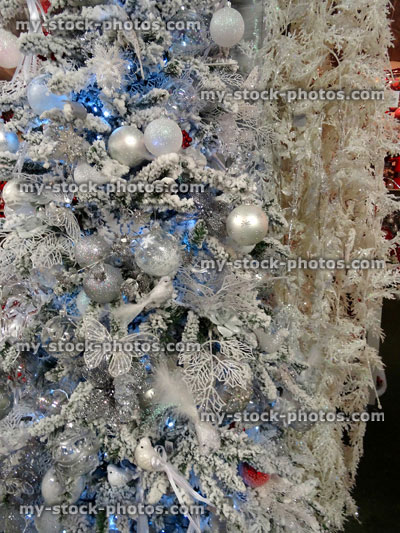 Stock image of artificial Christmas tree, white / silver decorations, glitter, birds, butterflies, baubles