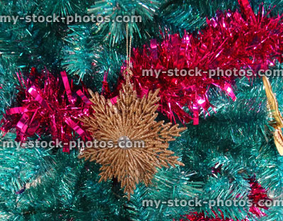 Stock image of tinsel Christmas tree, gold snowflakes, butterfly decorations and red tinsel