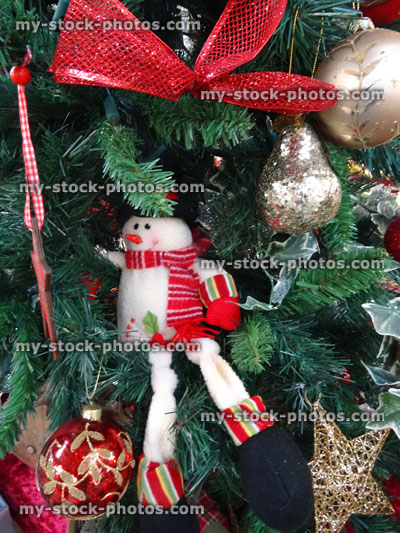Stock image of artificial Christmas tree, gold / silver / decorations, ivy, ribbons, snowman, baubles