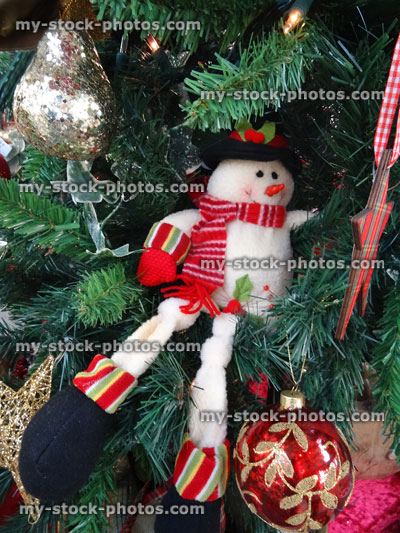 Stock image of artificial Christmas tree, gold / silver / decorations, ivy, ribbons, snowman, baubles