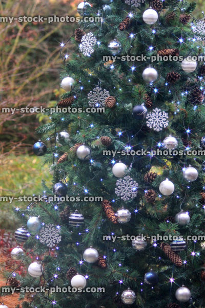 Stock image of an outdoor artificial Christmas tree, baubles decorations, fairy lights