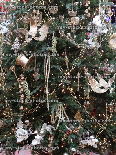 Stock image of artificial Christmas tree, silver decorations, tinsel, chains, garlands, masks, baubles