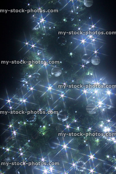 Stock image of Christmas tree star filtered, white led fairy lights, night background, bokeh