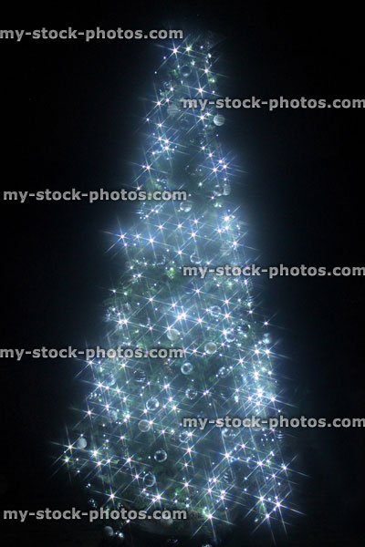 Stock image of Christmas tree star filtered, white led fairy lights, night background, bokeh