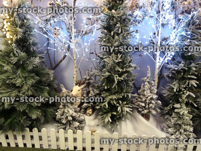 Stock image of winter forest woodland display, Christmas trees, snow, fairy lights, toy deer