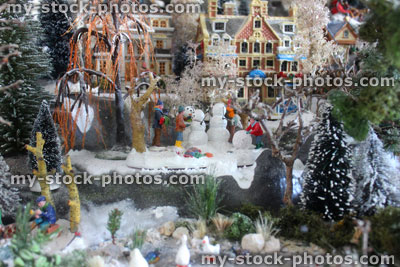 Stock image of model Christmas village, miniature houses, people, winter scene, fence, frozen pond, geese