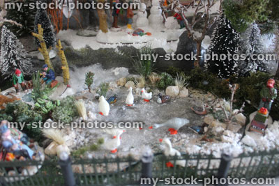 Stock image of model Christmas village, miniature houses, people, winter scene, fence, frozen pond, geese