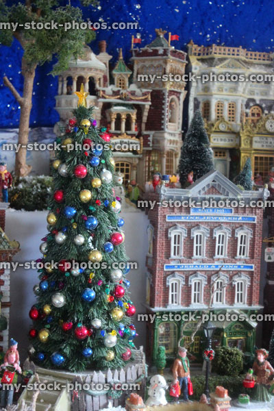 Stock image of model Christmas village with miniature houses, people, winter scene, lights, Christmas tree