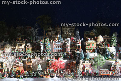 Stock image of model Christmas village with miniature houses, people, winter scene, night time lights