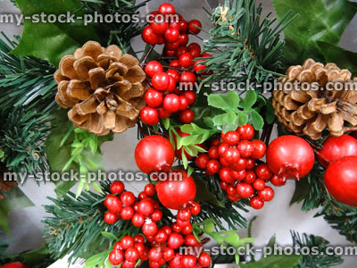Stock image of artificial Christmas tree wreath, pine cones, plastic holly berries, rose hips
