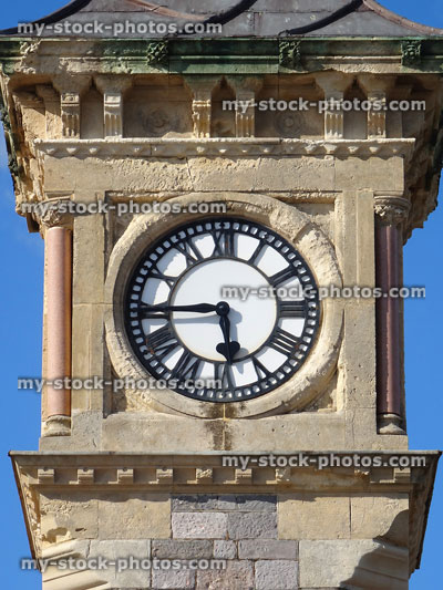 Stock image of stone clock tower with white clockface showing time