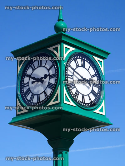 Stock image of green metal clock tower / clockface with Roman numerals