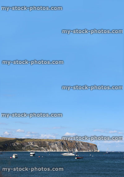 Stock image of harbour at seaside, with cliffs, boats, yachts, beach