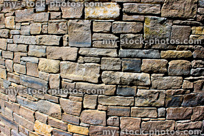 Stock image of irregular cobblestone wall curving round corner