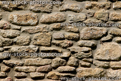Stock image of repointed cobblestone wall on exterior of old house