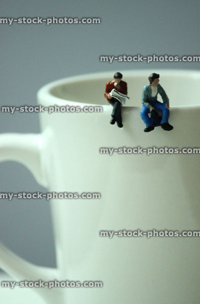 Stock image of coffee break with mini people sat on coffee mug