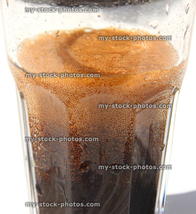 Stock image of fizzy cola being poured into glass, making bubbles