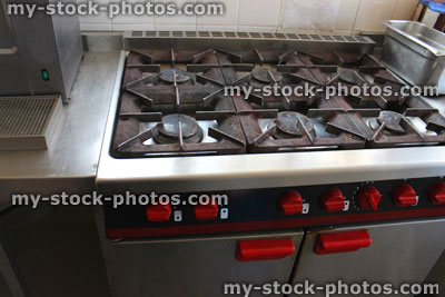 Stock image of dirty, rusty gas cooker hob in commercial kitchen