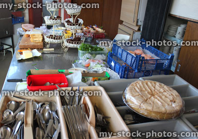 Stock image of commercial kitchen with cutlery knives and forks, cakes, sandwiches, chocolate brownies