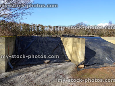 Stock image of large open front compost heaps, brick walls, garden waste