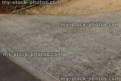 Stock image of cement concrete driveway contrasting with gravel / tarmac textures