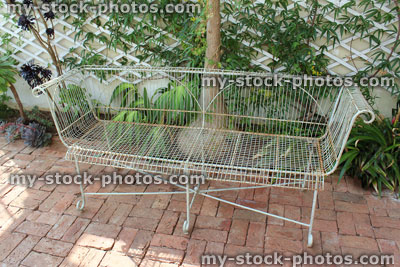 Stock image of white metal conservatory seat / bench, block paving, summerhouse