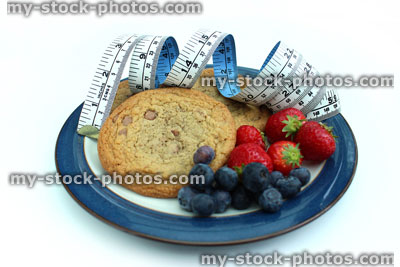 Stock image of tape measure with chocolate chip cookies, strawberries, blueberries