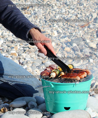 Stock image of man cooking food on beach barbecue, hot charcoal BBQ