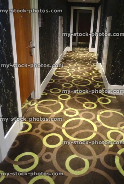 Stock image of hotel corridor, wooden bedroom doors, brown carpet circles