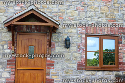 Stock image of wooden stable door on stone cottage house, with porch roof