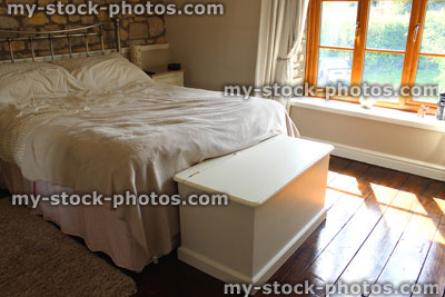Stock image of traditional cottage bedroom suite, with stone wall and wooden floor