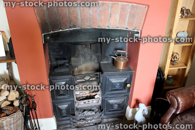 Stock image of traditional cast iron fireplace and hearth in English country cottage
