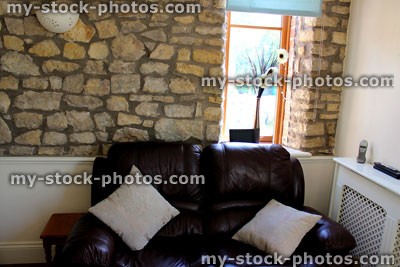 Stock image of traditional cottage sitting room / lounge, with exposed stone wall