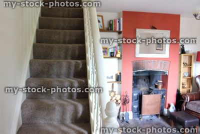 Stock image of traditional cast iron fireplace and staircase in English country cottage